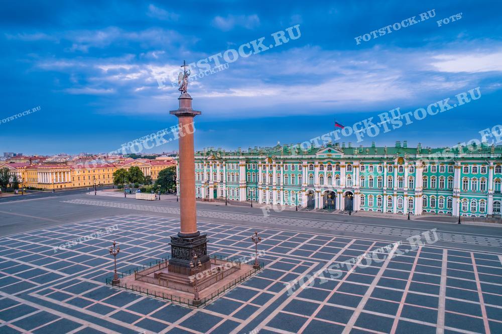 На фотографии представлен вид на Дворцовую площадь в Санкт-Петербурге с величественной Александровской колонной в центре. 
Фотография идеально подходит для использования в туристических публикациях, образовательных материалах и культурных статьях.